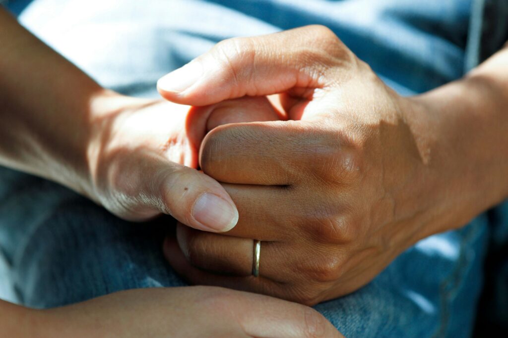 A photo of two people's hands clasped